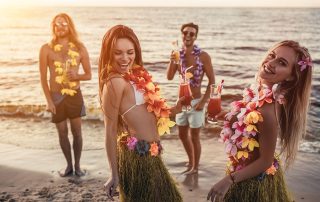 Group of friends enjoying tropical Hawaiian drinks on the beach