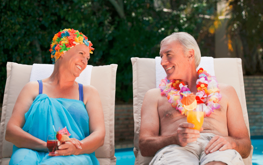 older couple enjoying a hawaiian margarita by the pool