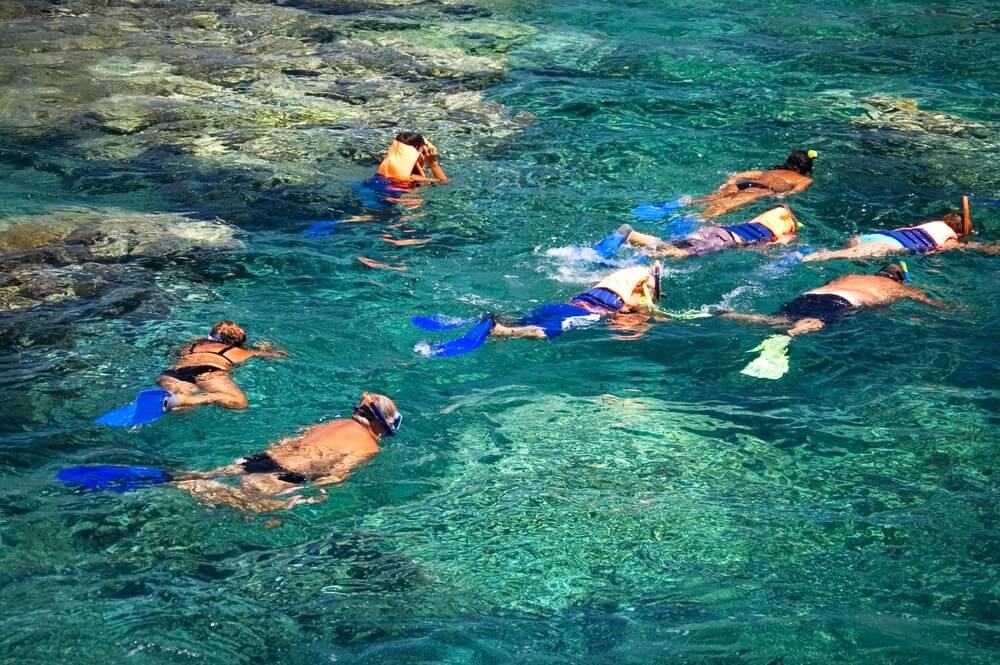 Hawaii vacationers snorkeling around coral reefs