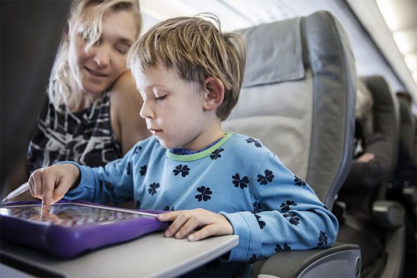 Child playing on his tablet during the flight.