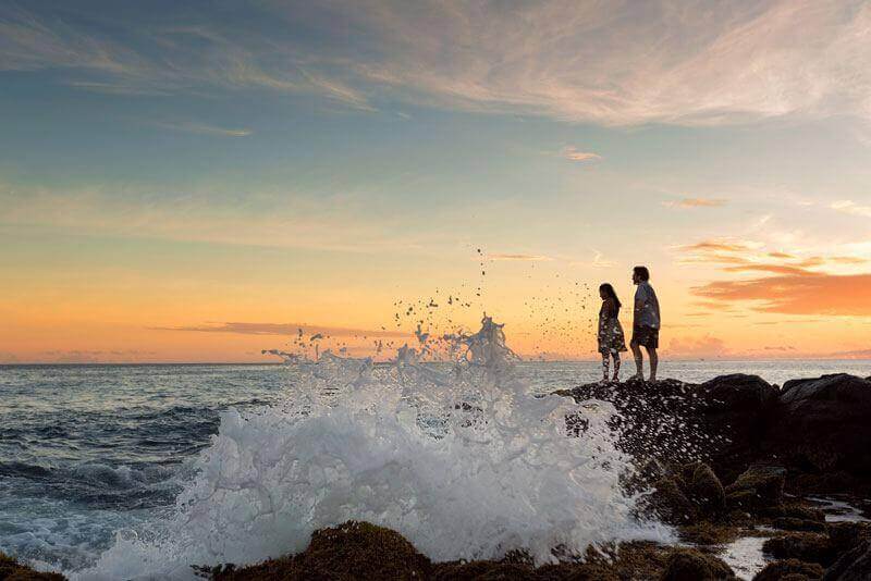 couple looking out into the ocean at Poipu beach park which is the best from the south shore beaches.
