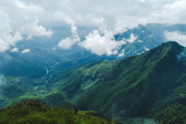 Panoramic mountain view of Mawsynram, India, with lush greenery and misty peaks.