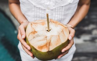 Holding a coconut drink concept image for the Hawaiian history of the coconut tree