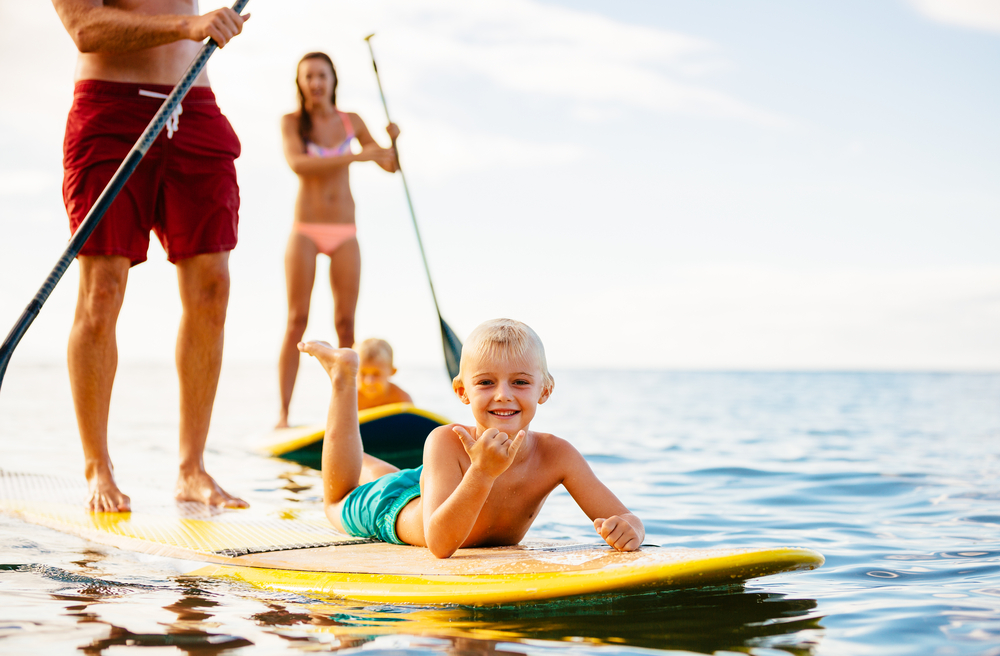 Family enjoying Kauai Paddle Boarding adventure on a tranquil ocean - North Shore bliss