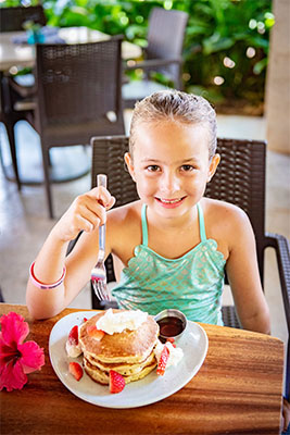 Young girl eating her breakfast at Holo Holo grill in Koloa landing resort.