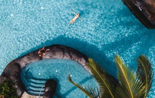Woman relaxing at the pool and jacuzzi at Koloa Landing resort in Kauai.