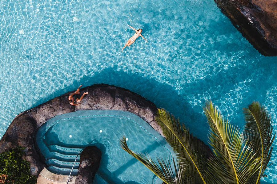 Woman relaxing at the pool and jacuzzi at Koloa Landing resort in Kauai.
