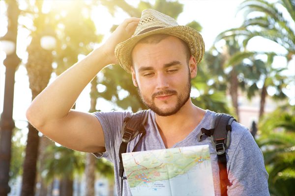 A thoughtful traveler studying a Kauai travel guide